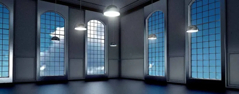 Stanza finestrata vuota, con poca luce, e dei lampadari con la luce accesa
